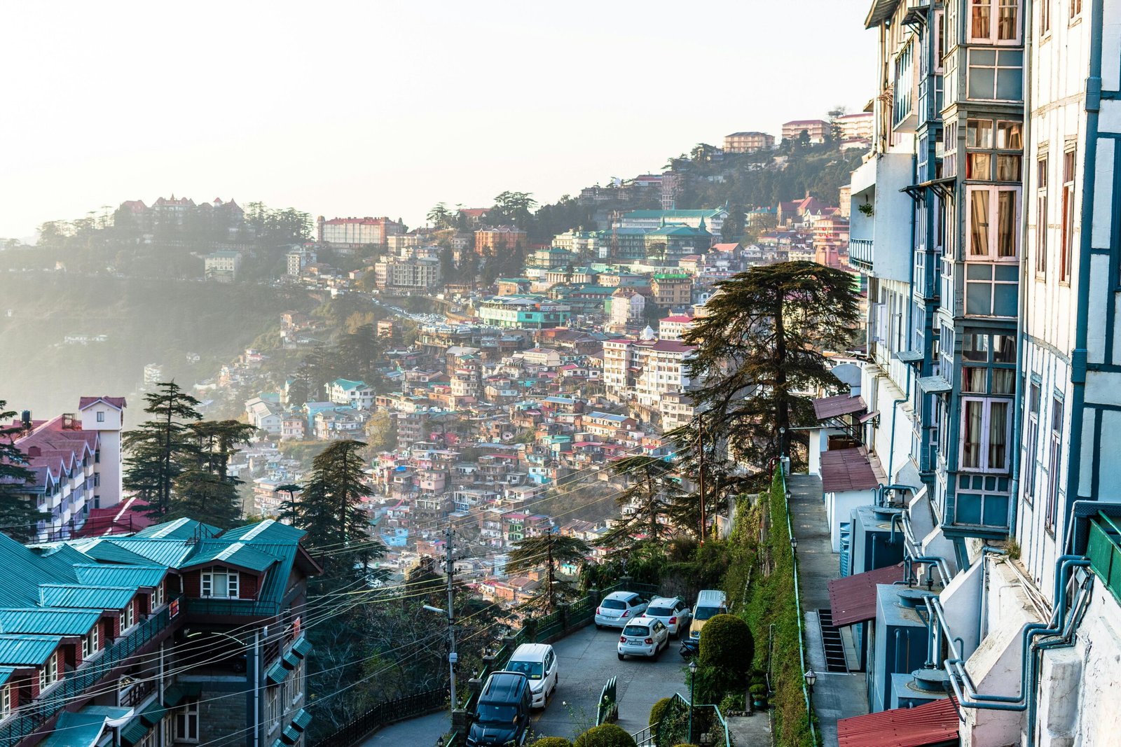 Colorful hillside cityscape with vibrant homes and lush greenery under daylight.